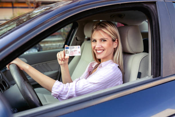 istock Young attractive woman holding her driving license 1133991331