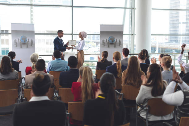 femme d'affaires recevant le prix d'homme d'affaires dans un séminaire d'entreprise - workshop applauding seminar business photos et images de collection