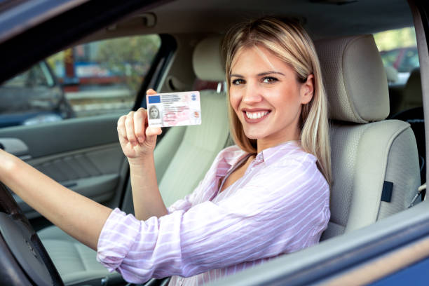 istock Young attractive woman holding her driving license 1133992257