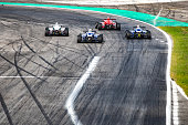 Men driving formula racing cars