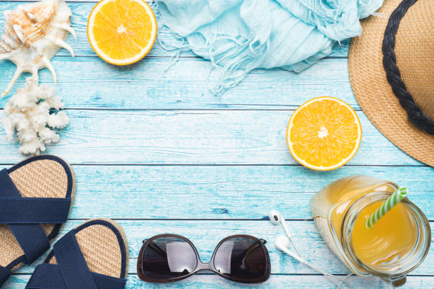 istock Blue sandals, hat and orange juice on blue background with copy space. concept summer vacation. Flat lay 1133992358