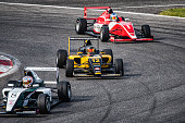 Men driving formula racing cars