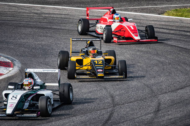 Men driving formula racing cars Men driving formula racing cars on motor racing track. extreme dedication stock pictures, royalty-free photos & images