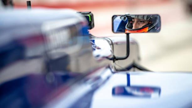 Man driving formula racing car Close-up of man driving formula racing car on motor racing track. extreme dedication stock pictures, royalty-free photos & images