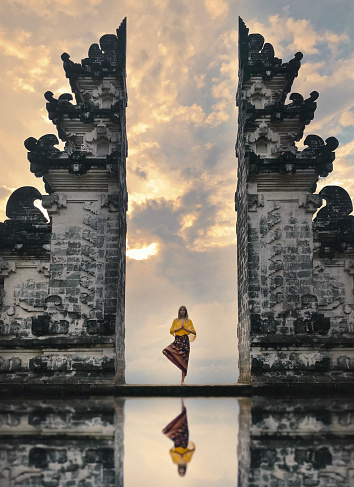 Girl is standing in the gate of Pura Lempuyang temple on Bali island