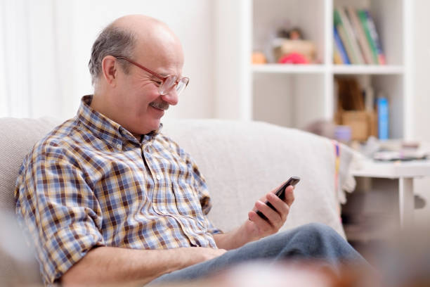 istock Mature hispanic man wearing eyeglasses checking messages on cell phone 1133996031