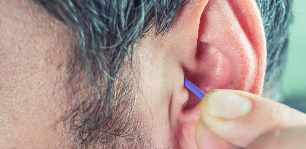istock a man cleans his ears with a cotton swab 1133997037