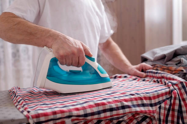 istock Senior man at home ironing his clothes 1133997191
