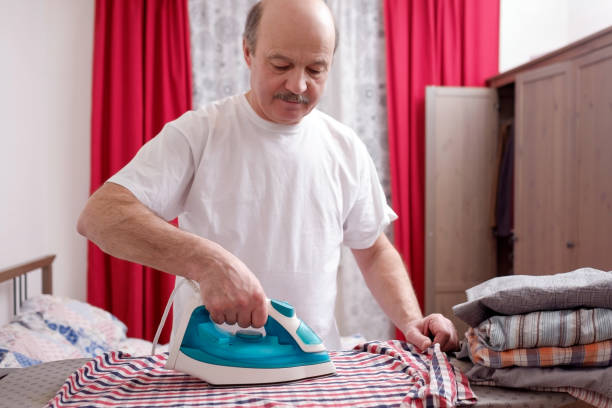 istock Senior man at home ironing his clothes. 1133997372