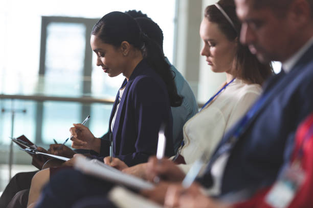 istock Business people writing on notepad in a business seminar 1133997445