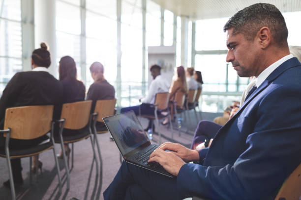 istock Businessman using laptop during business seminar 1133997773