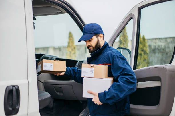 istock Delivery man with a parcel box in the car. 1133999190