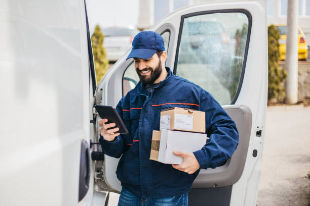 Delivery man with a parcel box in the car. - Stock image... Save