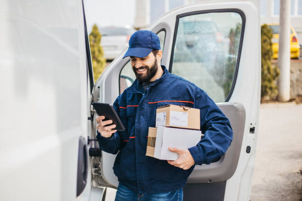 Delivery man with a parcel box in the car. - Stock image... Save stock photo
