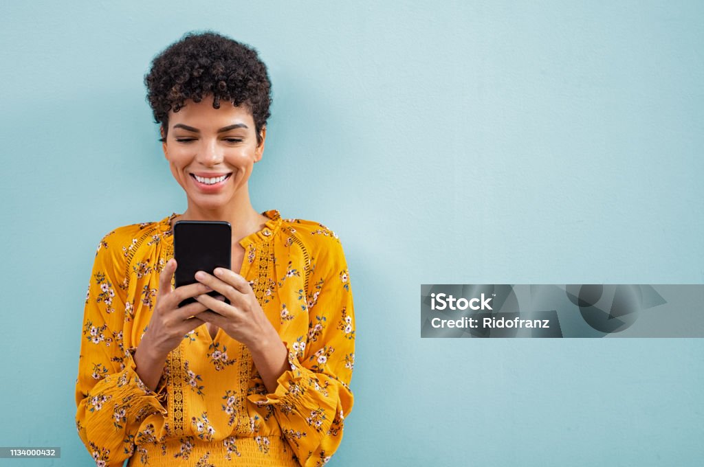 Mujer con estilo africano usando teléfono inteligente - Foto de stock de Personas libre de derechos