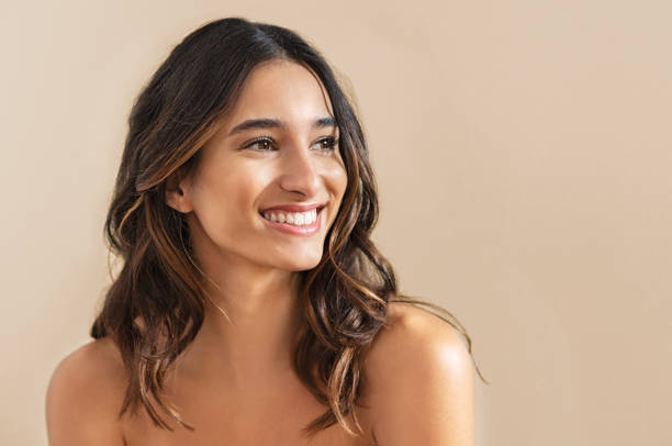 Smiling brunette woman Happy beauty woman looking away isolated on background. Cheerful young brunette with nude shoulder smiling after skin treatment. Beautiful hispanic girl waiting spa therapy. hair removal photos stock pictures, royalty-free photos & images