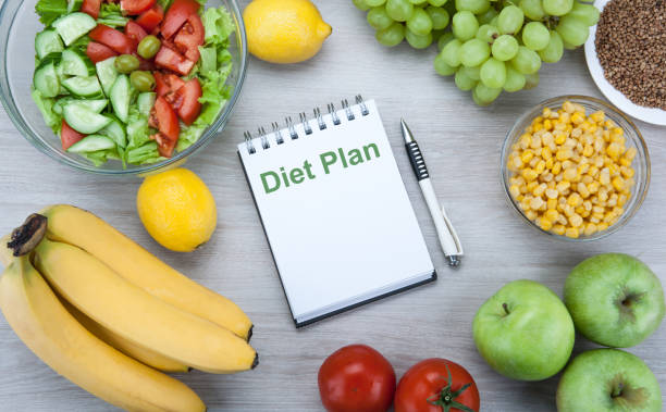 istock notebook with a diet plan with fresh vegetables and fruits on the table top view 1134000566