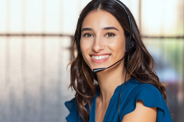 Beautiful call center consultant Customer support woman smiling and looking at camera. Portrait of happy customer support phone operator at call center wearing headset. Cheerful executive at your service working at office. customer service representative photos stock pictures, royalty-free photos & images