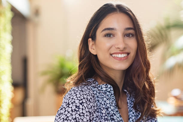 Happy young woman smiling Closeup face of happy smiling young woman. Portrait of beautiful latin girl looking at camera. Confident casual girl sitting at cafeteria. latin woman stock pictures, royalty-free photos & images