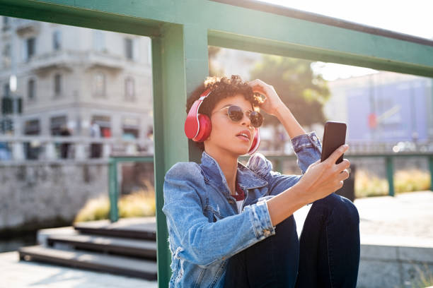 stylowa afrykańska kobieta słuchająca muzyki - city street audio zdjęcia i obrazy z banku zdjęć