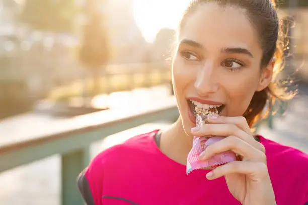 Photo of Sporty woman eating energy bar