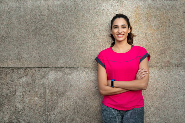 Sporty woman leaning against wall