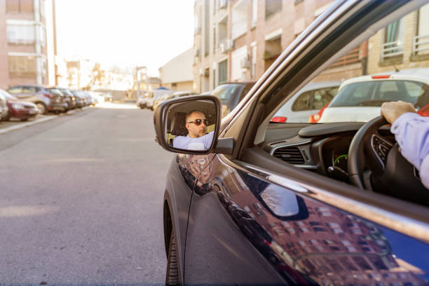 istock Man of style and status. Handsome young man in full suit smiling while driving a car 1134004926
