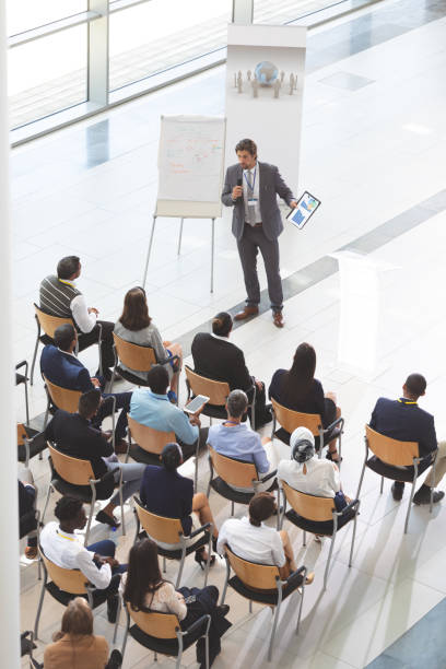 biznesmen mówiący z cyfrowym tabletem przemawia na seminarium biznesowym - lecture hall audio zdjęcia i obrazy z banku zdjęć