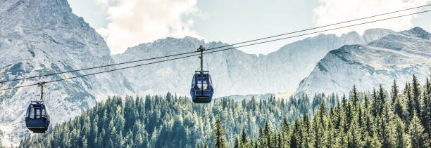dos cabinas del teleférico y los esquiadores en la ladera de la montaña chopok lado sur en un día soleado en el esquí - overhead cable car summer ski lift scenics fotografías e imágenes de stock