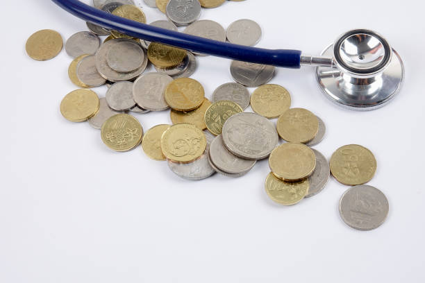 istock Close-Up Of Coins With Stethoscope Over White Background 1134012975