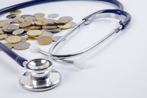 istock Close-Up Of Coins With Stethoscope Over White Background 1134014625