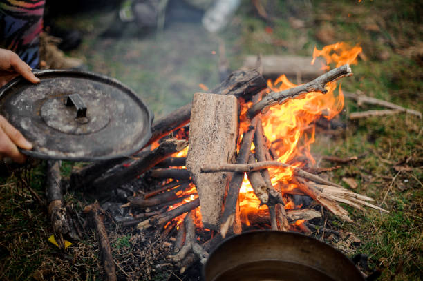 istock Man holding cover placing on the pan near the campfire 1134014875