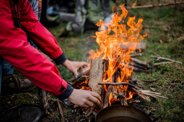 istock Man in the red jacket placing a firewood to the campfire 1134014984