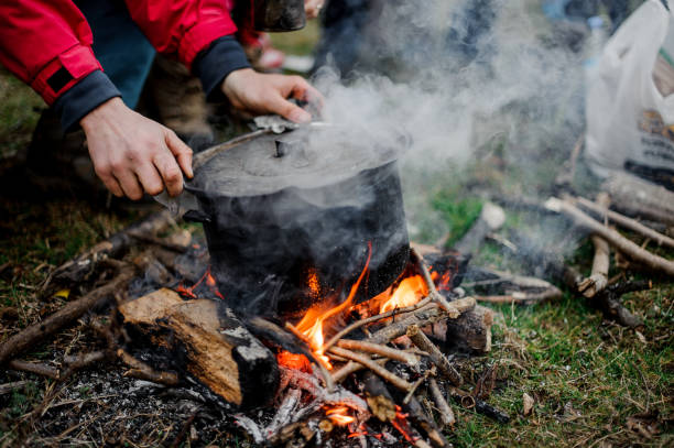 istock Man placing a cover on the black pan standing on the bonfire 1134015066