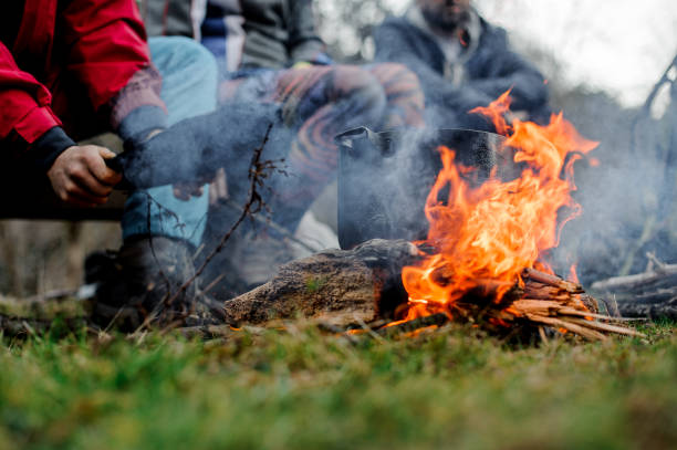 istock Man waving a blow on the pan on the bonfire 1134015184