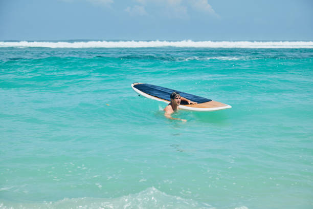 Surfer man with surfboard enjoying on the beach. Summer concept.