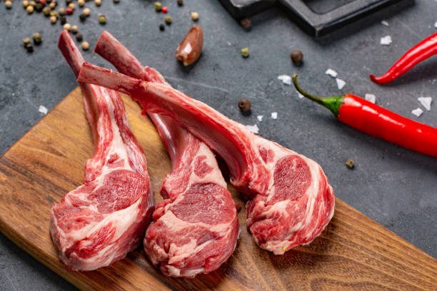 istock Raw meat on the bone with fresh herbs and spices, black background for cooking with copy space, top view. 1134015929