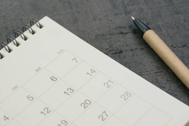 white clean calendar with pen on dark blackboard desk using as reminder, plan or personal diary concept - today reminder note pad writing imagens e fotografias de stock