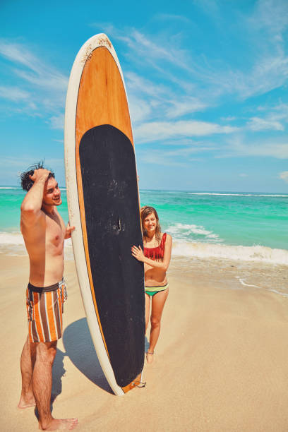 istock Couple with surfboard enjoying on the tropical beach. 1134016724