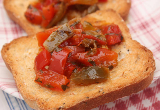 Toasts Red and green pepper marinated in olive oil Toasts Red and green pepper marinated in olive oil and aromatic plants grillade stock pictures, royalty-free photos & images
