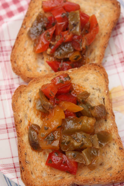 Toasts Red and green pepper marinated in olive oil Toasts Red and green pepper marinated in olive oil and aromatic plants grillade stock pictures, royalty-free photos & images