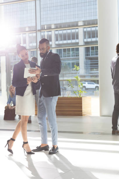 istock Diverse business people looking and discussing over digital tablet in lobby office 1134018183
