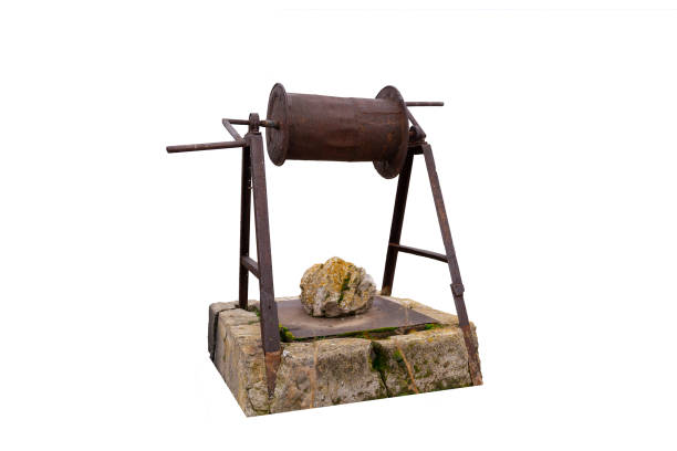 Traditional Turkish iron water well with pulley isolated on white background, Abandoned and closed with a rock