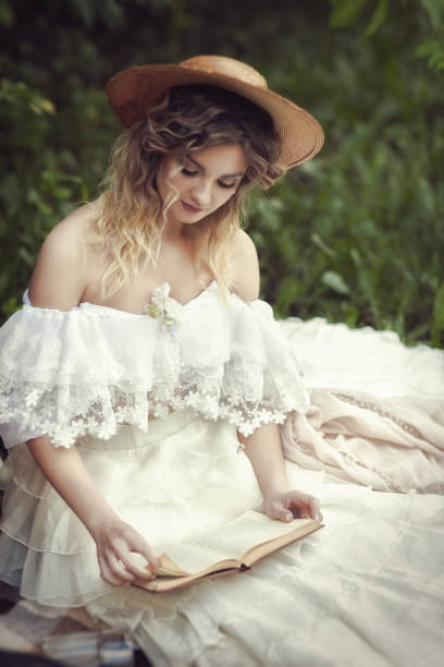 beautiful blonde in vintage white dress reading a book