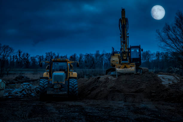 excavator and a truck at moonlight