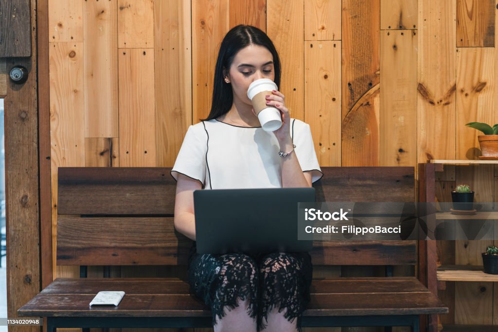 Giovane imprenditrice adulta che lavora con un laptop in città - Foto stock royalty-free di Adolescente Giovane imprenditrice adulta che lavora con un laptop in città - Foto stock royalty-free di Adolescente