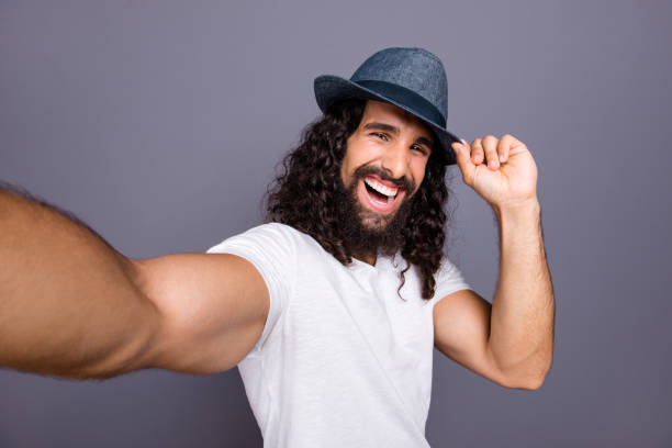 istock Self-portrait of his he nice attractive cheerful cheery optimistic wavy-haired guy touching hat isolated over gray violet purple pastel background 1134022416