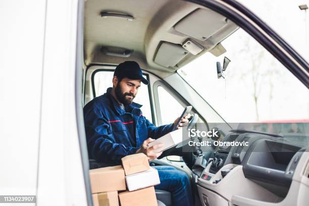 Delivery Man With A Parcel Box In The Car Stock Photo - Download Image Now - Delivery Person, Package, Telephone