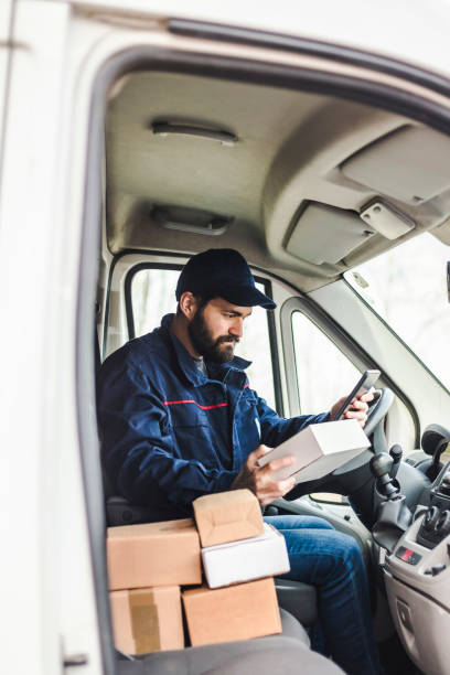 istock Delivery man with a parcel box in the car. 1134023930