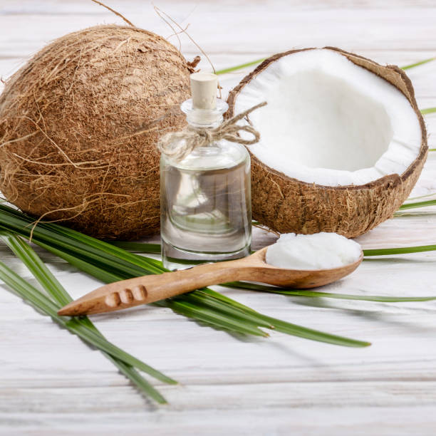 istock Coconut shell pieces and palm leaves on white wooden table 1134025150